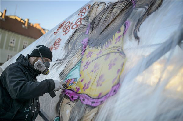 A Mr. Zero művésznevű graffitiművész festékszóróval fest az egri Gárdonyi téren 2015. április 7-én.